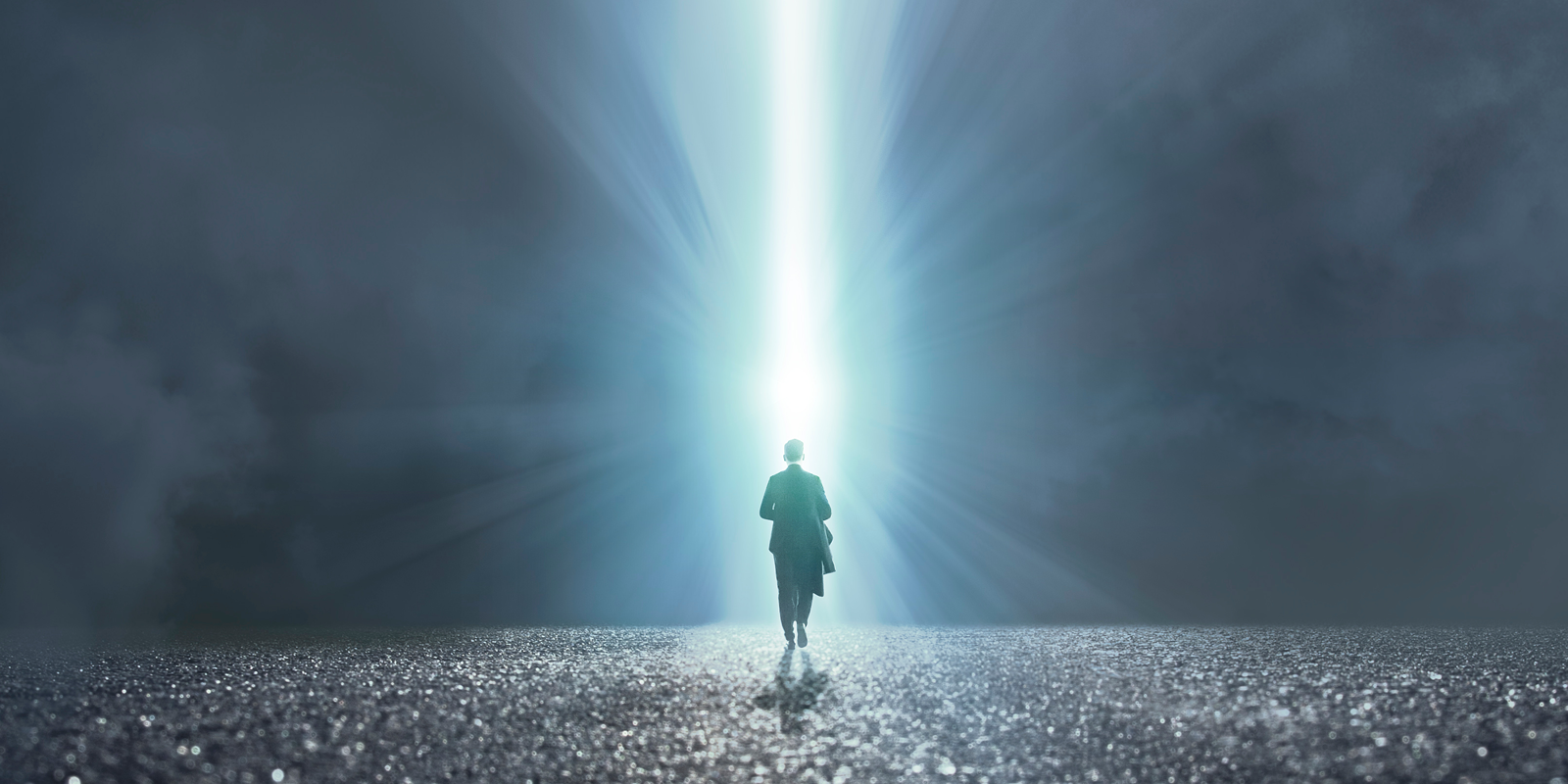 Person walking into a beam of light signifying clarity and focus