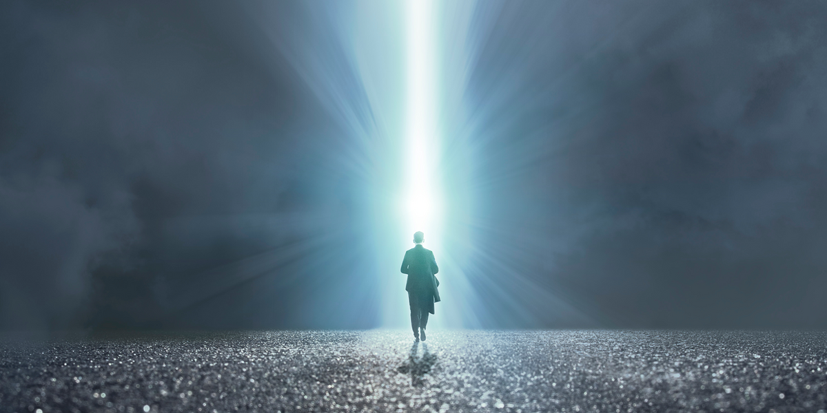 Person walking into a beam of light signifying clarity and focus