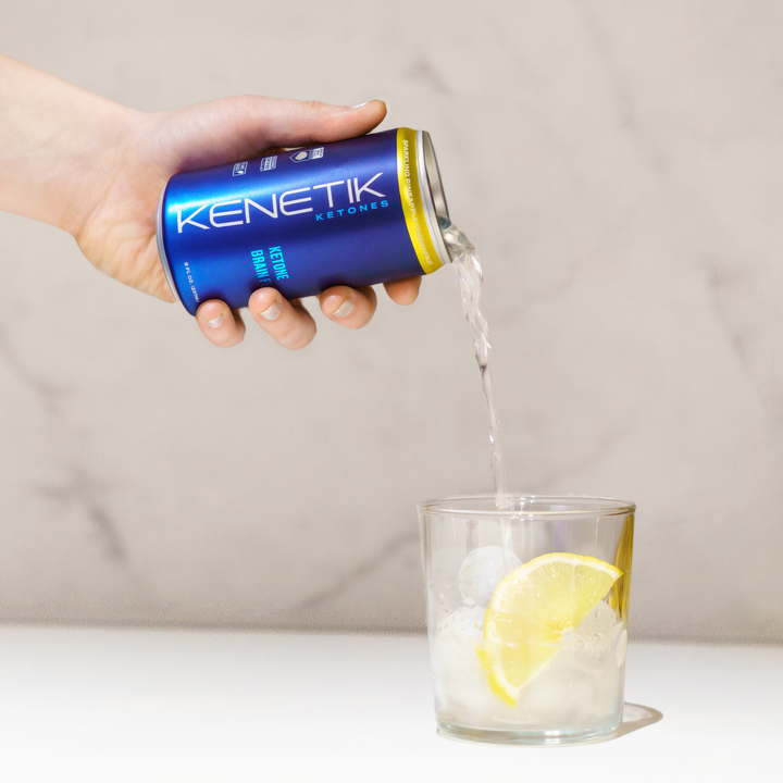 Kenetik RTD in a can being poured into a glass with ice and lemon